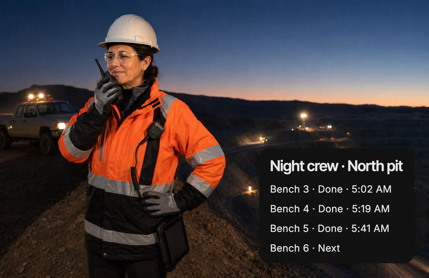 Luz, the night-shift superintendent, at the rim of an open-pit mine before dawn, speaking into her radio as haul trucks’ lights move along the benches below; the crew’s shared page shows Bench 5 done at 5:41 AM.