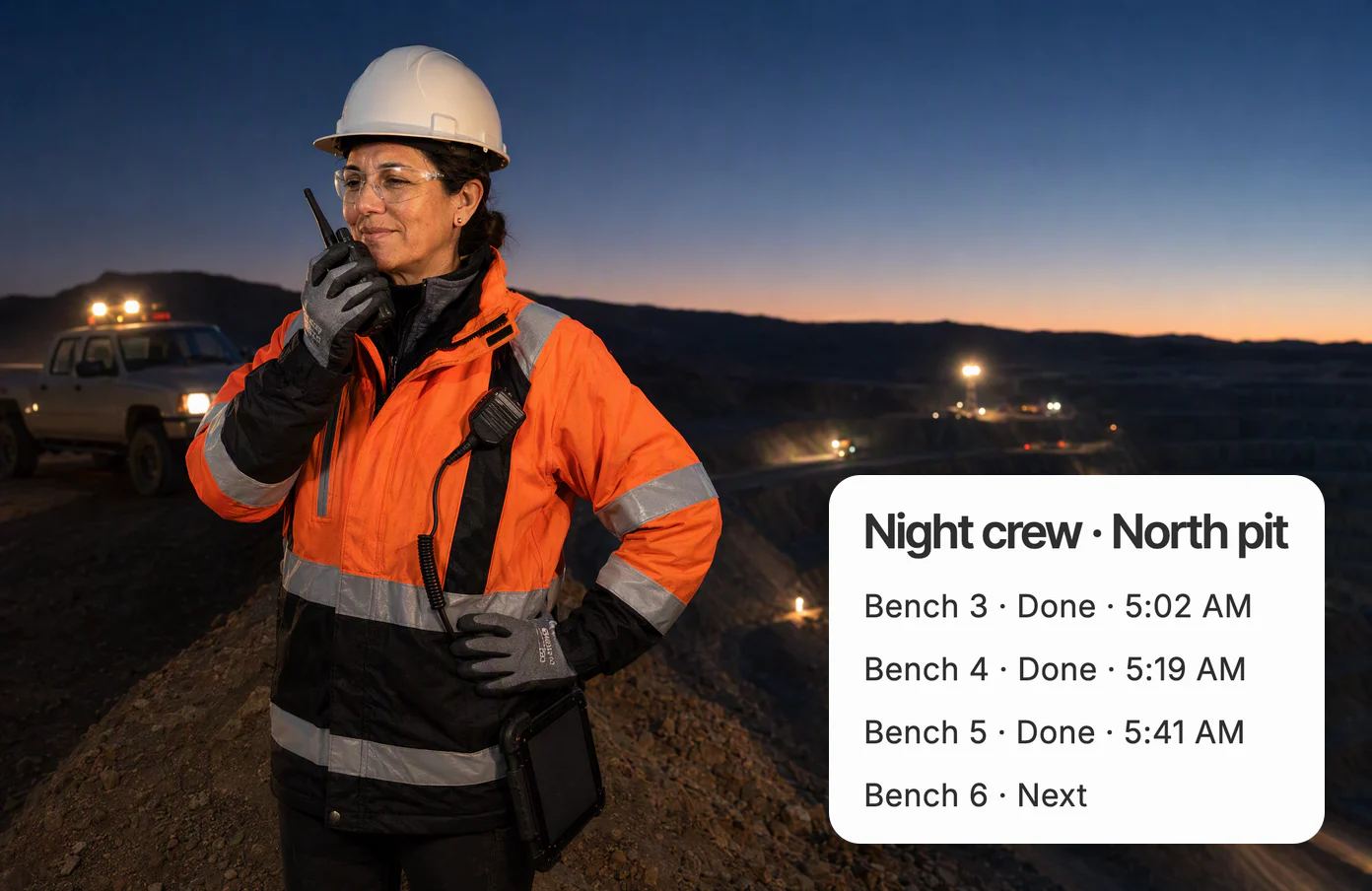 Luz, the night-shift superintendent, at the rim of an open-pit mine before dawn, speaking into her radio as haul trucks’ lights move along the benches below; the crew’s shared page shows Bench 5 done at 5:41 AM.