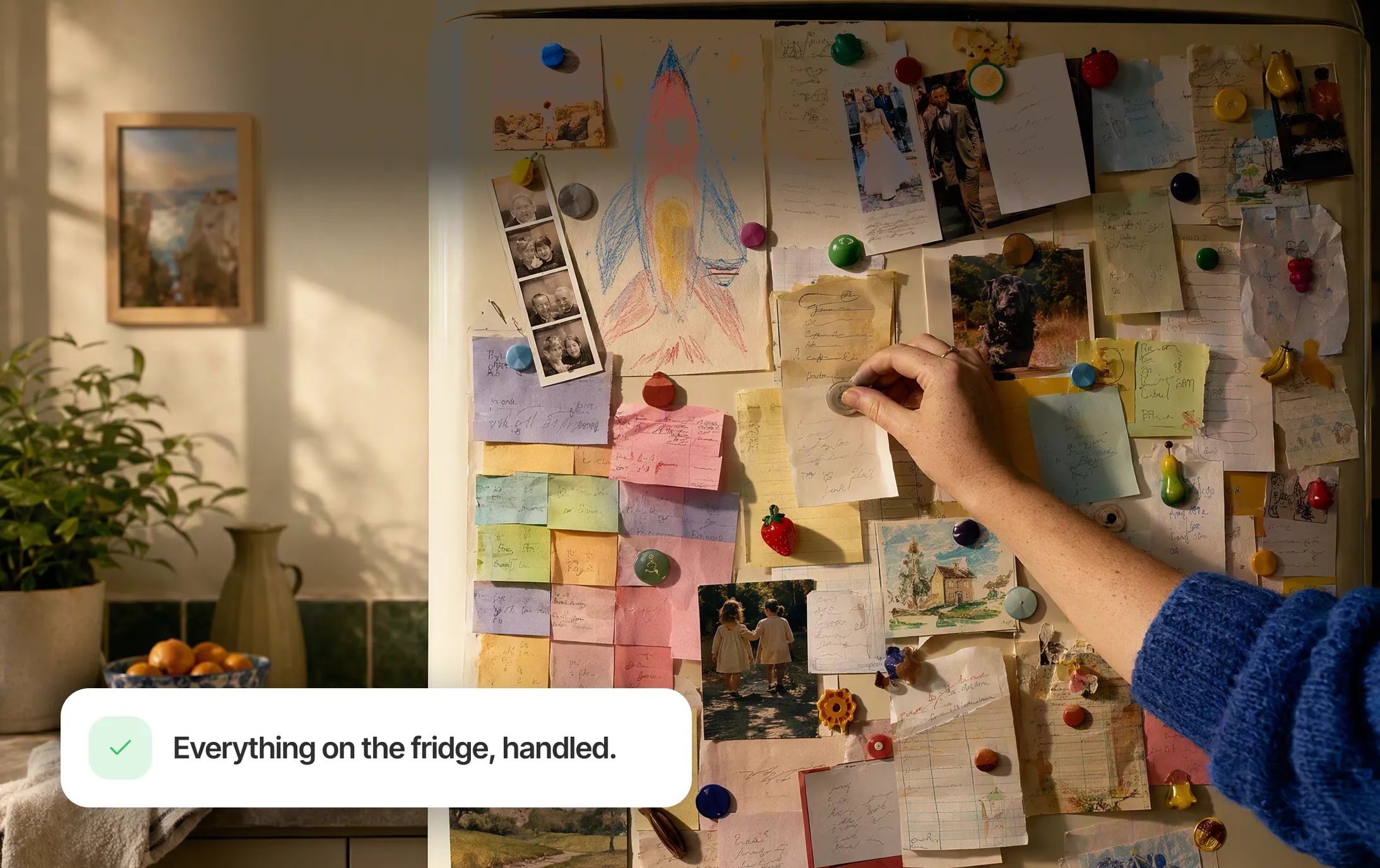A family fridge door covered edge to edge in notes, drawings, photos and schedules, a hand in a cobalt sleeve pinning one more, and Dvina's answer beside it: “Everything on the fridge, handled.”