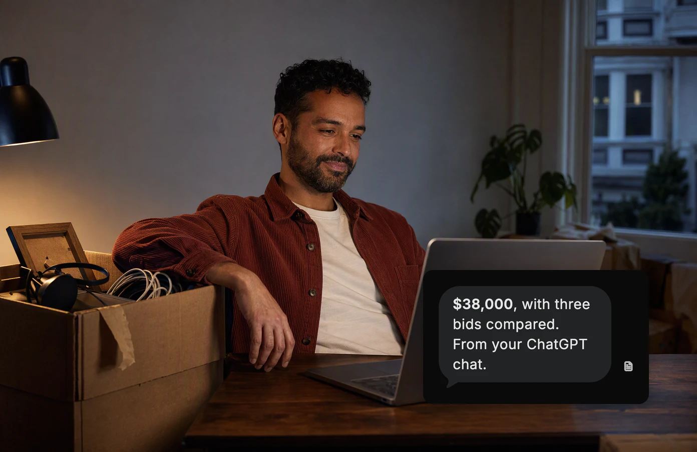 A man at his desk beside an unpacked moving box. Dvina’s answer: $38,000, with three bids compared, from a chat he brought in from another assistant.