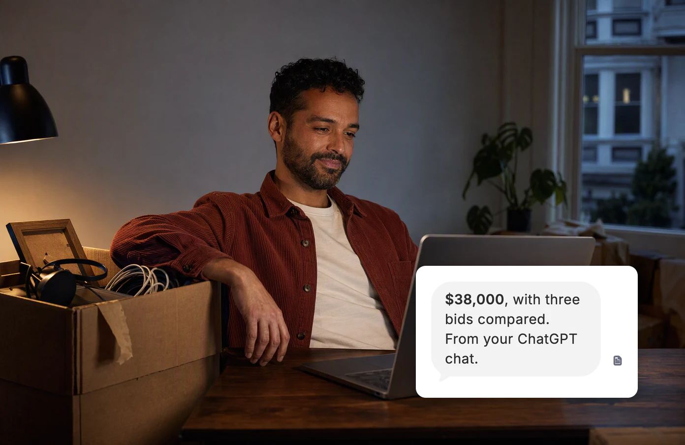 A man at his desk beside an unpacked moving box. Dvina’s answer: $38,000, with three bids compared, from a chat he brought in from another assistant.
