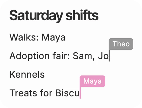 A shared page in Dvina, Saturday shifts, with two people writing on it at once: Theo’s caret after “Adoption fair: Sam, Jo” and Maya’s mid-word on “Treats for Biscu”.