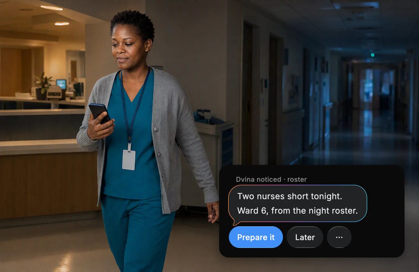 A nurse manager walks a quiet ward corridor at 2 AM reading her phone. Dvina: two nurses short tonight, from the night roster.