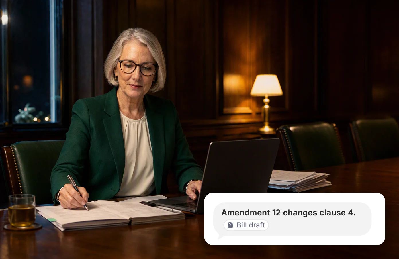 A committee clerk marks a printed bill in an empty committee room at 11 PM. Dvina: amendment 12 changes clause 4, from the bill draft.